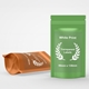 Two stand-up pouches, one green and one bronze, each with a large transparent rectangular label featuring white print and laurel wreath design. Label size is 99mm x 139mm, ideal for customised or personalised branding on food, supplements or product packaging.