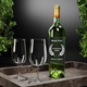 Green wine bottle with a gold foil top and large transparent rectangular label featuring white print and a laurel wreath design, placed beside two empty wine glasses on a stone tray. Ideal for customised or personalised bottle branding, size 99mm x 139mm.