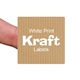 A close-up of a square kraft paper label with white text reading White Print Kraft Labels, held between fingers. The custom label has a subtle striped brown texture and rounded corners, showing its compact size and natural paper look.