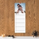 Personalised photo kitchen planner calendar hanging on a wooden wall with daily spaces for notes.