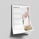 A 2026 wall planner calendar is shown open to February, hanging on a light grey wall. The layout features a vertical list of dates with space for daily notes on the left and a full-length photo of a smiling young boy in a white vest and beige trousers on the right. The calendar is spiral-bound with a central hanging hook, designed for easy use and personalisation.