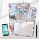 Two A4 photo calendars for 2025, The front calendar features your own image. A smartphone and pen are placed next to the calendars on a white desk, with space for notes in the month grids.