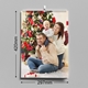 An A3 wall calendar with dimensions of 297mm width and 420mm height. The page features a family posing in front of a Christmas tree with festive decorations. The calendar has spiral binding and a hanging hook.