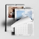 Two A4 wall calendars with marble designs. One displays a Christmas-themed family photo for December, and the other shows a landscape image of the sky with a page being turned. Both calendars feature monthly grids and spiral bindings with hanging hooks.