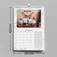 An A3 wall calendar for December 2025 with dimensions of 297mm width and 420mm height. The page features a family Christmas photo with festive decorations and a marble design border. The calendar includes a monthly grid, spiral binding, and a hanging hook.