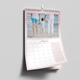 An A3 wall calendar for January 2025 with a pink glitter border. The page features a photo of a child holding hands with two adults at the beach, with a monthly grid below. The calendar is spiral-bound with a hanging hook.