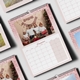 A December 2025 page from an A3 pink glitter-themed photo calendar. The image features a family posing in front of a Christmas tree with festive decorations. The calendar includes a large monthly grid layout.