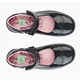 A pair of black patent leather children's shoes with pink insoles, each featuring a personalised name label with a green background and a pink giraffe design, placed inside the shoes for easy identification.