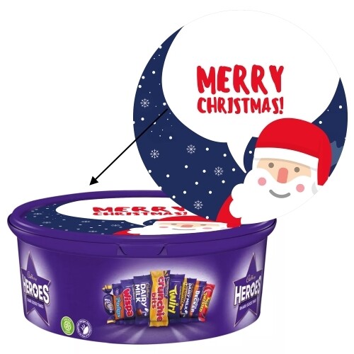 Purple Cadbury Heroes tub with personalised Christmas sticker on the lid, featuring a smiling Santa illustration and the message 