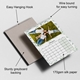 A 2026 wall calendar is open to February, featuring a smiling family lying on grass in matching white tops. The calendar includes callout labels highlighting its features: an easy hanging hook, wire binding for smooth page turning, sturdy greyboard backing for durability, and 170gsm silk paper for a premium feel. The design is framed with a soft green leaf border and a clean date layout.