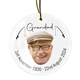 White ceramic bauble with a gold hanging string, featuring a smiling elderly man wearing glasses and a checkered flat cap. Text reads 