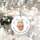 Round ceramic bauble featuring a photo of an elderly man with short grey hair and a beard, hanging from a snowy tree branch. The word 