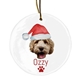 Personalised ceramic Christmas bauble featuring a dog's face wearing a festive Santa hat. Below the image, the name 