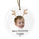 Personalised ceramic Christmas bauble featuring a child’s smiling face wearing reindeer antlers. Below the image, the text reads 