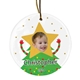 Personalised ceramic Christmas bauble featuring a child’s smiling face on a star topper, with a green Christmas tree body and striped arms. Gold dots decorate the background, and the text reads 