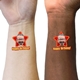 Two wrists, one light-skinned and one dark-skinned, each displaying a red star-shaped temporary tattoo with a man's face and the text Happy Birthday! The tattoos stand out as a fun, celebratory detail.