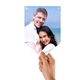 A hand holding a piece of personalised bunting with a photo of a smiling couple embracing on a sunny beach, featuring a bright blue sky and ocean backdrop.