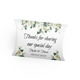 Personalised wedding favour pillow box with a floral design featuring white blossoms and green leaves. The box has elegant script text reading Thanks for sharing our special day, with the names Taylor & Travis and the date 04/03/2025.