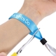 A personalised fabric wristband being cut off a wrist with scissors. The wristband features customisable text and a secure black plastic lock. Ideal for festivals, events, or promotions.