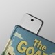 Blank white bookmark with a top hole inserted into a closed illustrated book titled The GOAT. The bookmark has a smooth finish and rounded corners, ideal for personalised printing or custom use. Set against a light grey background.