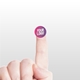 Close-up of a hand holding a small, personalised circular label with a custom logo on the fingertip, set against a light background. The label is pink and purple with the text Your Logo in white.