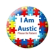 A close-up of a round badge with a colourful jigsaw puzzle pattern with text reading 