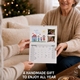 Woman receiving a handmade personalised 2027 wall calendar decorated with family drawings and photographs.