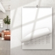 Blank A4 wire-bound calendar hanging in a home with a page turning to reveal the monthly date grid.