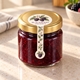 Blackberry preserve jar with a floral lollipop seal sticker running from the gold lid down the front.