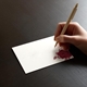 a hand writing on a beautifully printed place card with wedding guest names