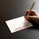 a hand writing on a beautifully printed place card with wedding guest names