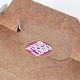 Brown kraft box with a personalised round kraft label featuring the text Your Logo in bold pink and white, placed on the handle flap. Ideal for customised packaging or branding.