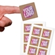 Close-up of a hand holding a small square custom sticker with bold text in pink, white, and yellow on a kraft background. Two sheets of identical stickers are displayed below. Perfect for personalised labelling and branding.