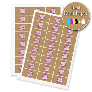 Sheets of rectangular kraft labels printed with a personalised design featuring the text Your Logo in bold pink and white on a brown kraft paper background. A badge in the corner highlights Real Kraft Paper with colour printing options.