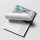 Personalised A3 family photo calendar with a wire binding and page being turned above the monthly grid.