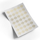 A sheet of custom transparent foil stickers featuring a gold-foil design that reads Your Design Here. The stickers are arranged in a grid pattern on a white backing sheet, reflecting light for a premium look. The sheet is slightly curled at the corner.