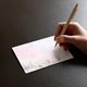 a hand writing on a beautifully printed place card with wedding guest names