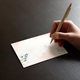 a hand writing on a beautifully printed place card with wedding guest names