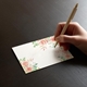 a hand writing on a beautifully printed place card with wedding guest names