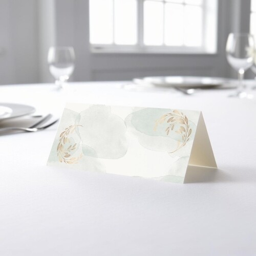 blank wedding place card with an elegant design printed on folded white cardstock, ready to write your names. Placed on a table set for a formal event, with plates, cutlery, and wine glasses in the softly blurred background.