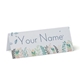 Personalised wedding place card with your name in elegant design on folded white cardstock. Minimalist design, set against a plain white background for a clean and sophisticated look.