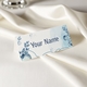 Personalised wedding place card with your name in elegant design on folded white cardstock. Set on a softly draped ivory tablecloth, creating a sophisticated and timeless look.