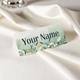 Personalised wedding place card with your name in elegant design on folded white cardstock. Set on a softly draped ivory tablecloth, creating a sophisticated and timeless look.